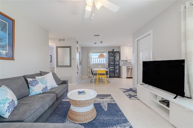 living area featuring a ceiling fan, baseboards, visible vents, and light floors