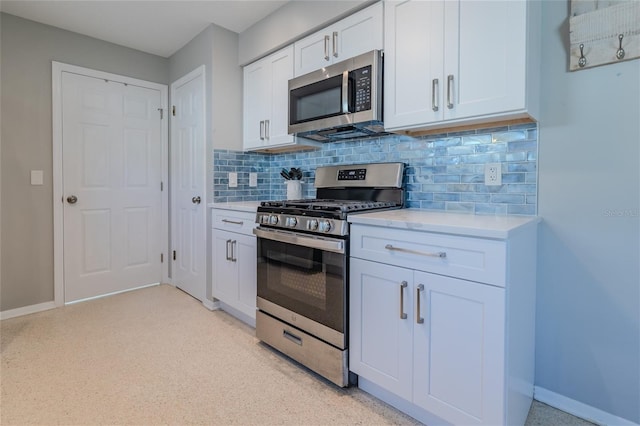 kitchen with light countertops, appliances with stainless steel finishes, white cabinetry, and baseboards