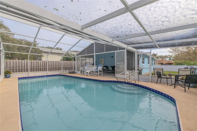 view of pool featuring a fenced in pool, a patio area, glass enclosure, and a fenced backyard