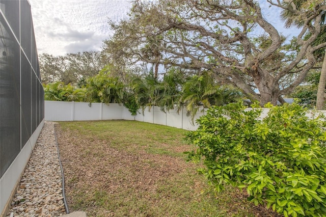 view of yard with a lanai and a fenced backyard