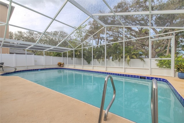 view of pool featuring glass enclosure, a fenced backyard, a patio area, and a fenced in pool