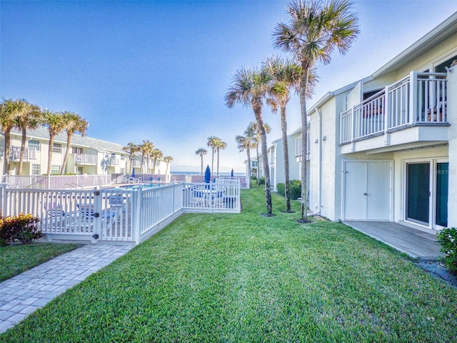 view of yard featuring a balcony and a fenced in pool