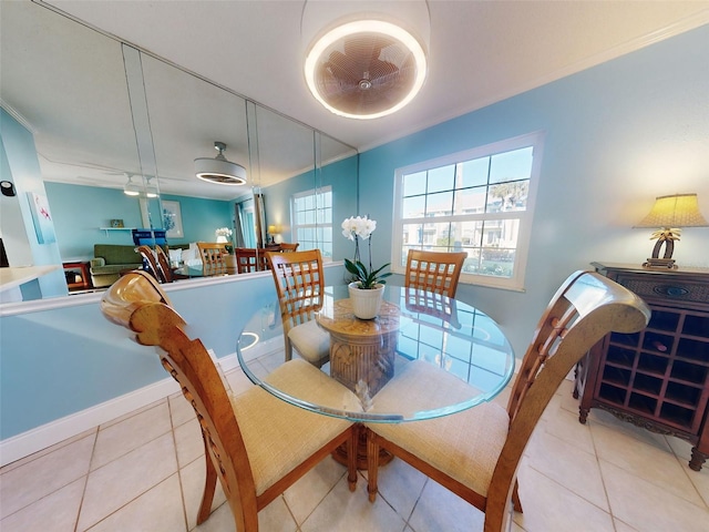 tiled dining room featuring ceiling fan and ornamental molding