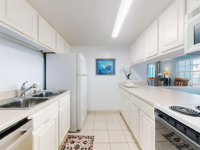 kitchen with white appliances, white cabinets, light tile patterned floors, and sink