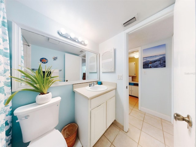 bathroom with toilet, tile patterned floors, and vanity