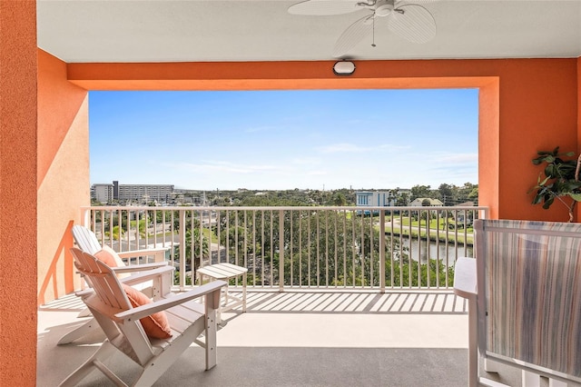 balcony featuring ceiling fan and a water view