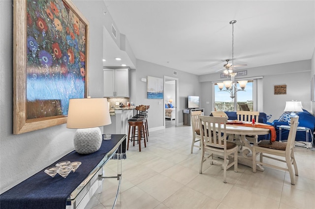 dining area featuring ceiling fan with notable chandelier