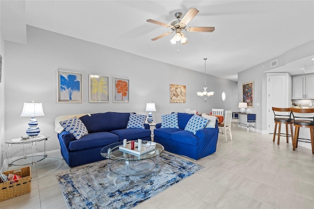 living room with ceiling fan with notable chandelier and light tile patterned floors