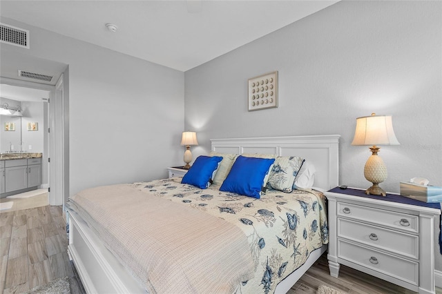 bedroom featuring hardwood / wood-style floors and connected bathroom