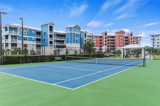 view of tennis court with basketball hoop