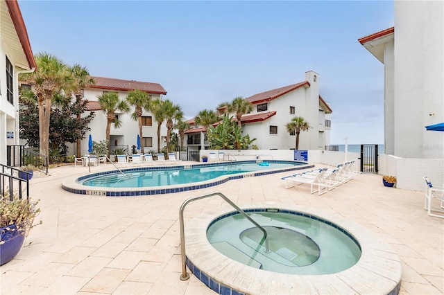 view of pool featuring a patio and a hot tub