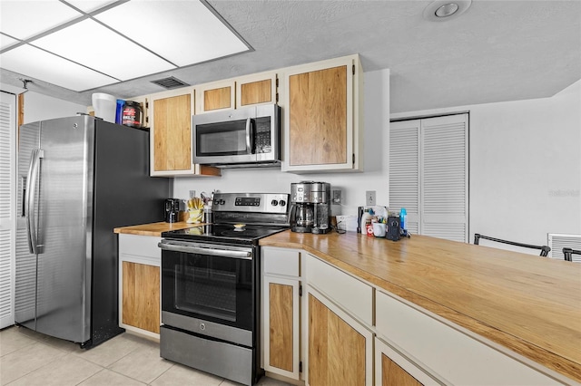 kitchen with appliances with stainless steel finishes and light tile patterned flooring