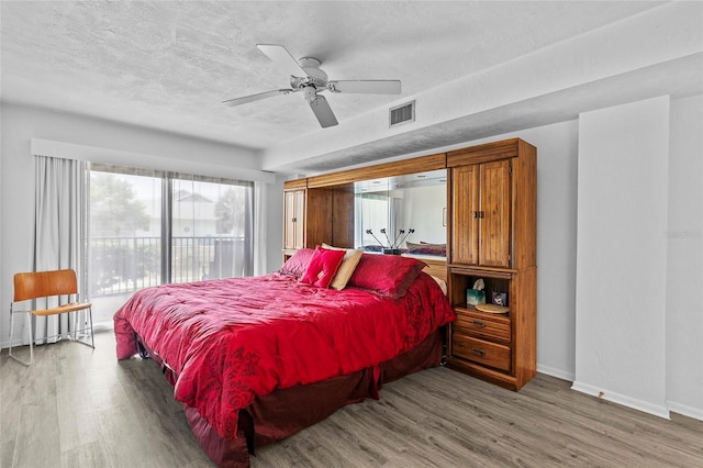 bedroom featuring ceiling fan, a textured ceiling, and hardwood / wood-style flooring