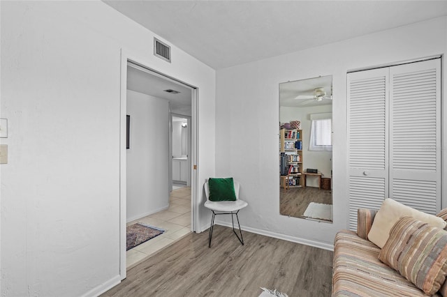 sitting room featuring light wood-type flooring and ceiling fan