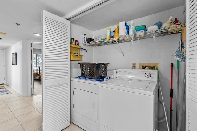 laundry room featuring light tile patterned flooring and washing machine and dryer