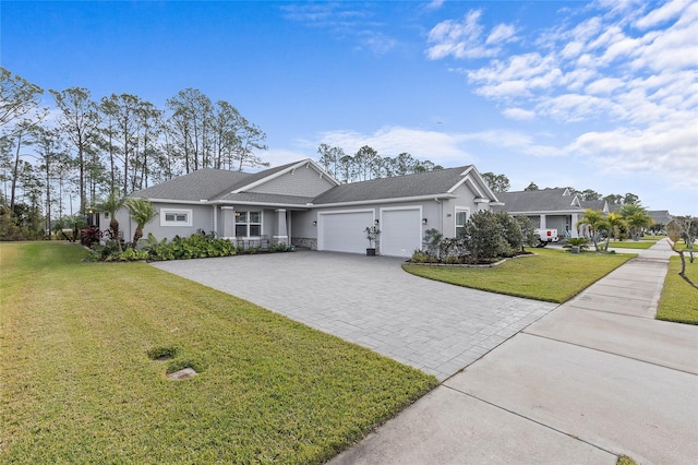 single story home featuring decorative driveway, a front lawn, an attached garage, and stucco siding