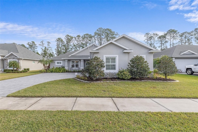 ranch-style home featuring stucco siding, decorative driveway, and a front lawn