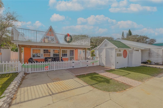 view of front of house featuring a balcony and a storage unit