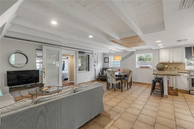 tiled living room featuring beam ceiling