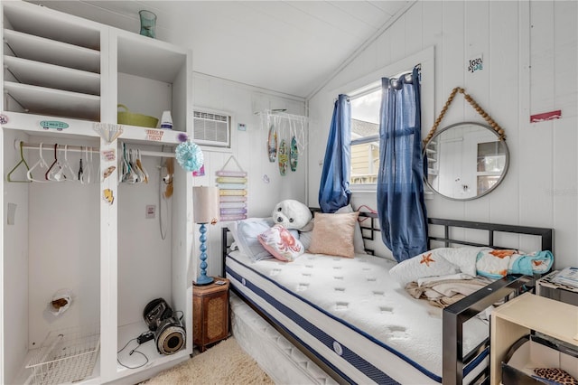 bedroom with wood walls and vaulted ceiling