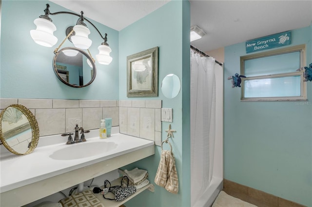 bathroom with a shower with curtain, decorative backsplash, and sink