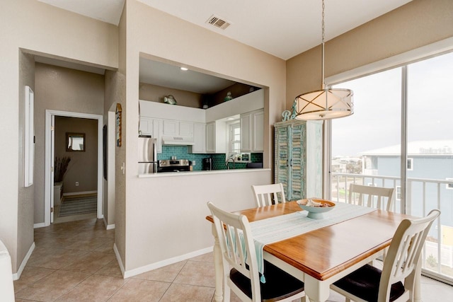 dining space featuring light tile patterned floors, a healthy amount of sunlight, and sink