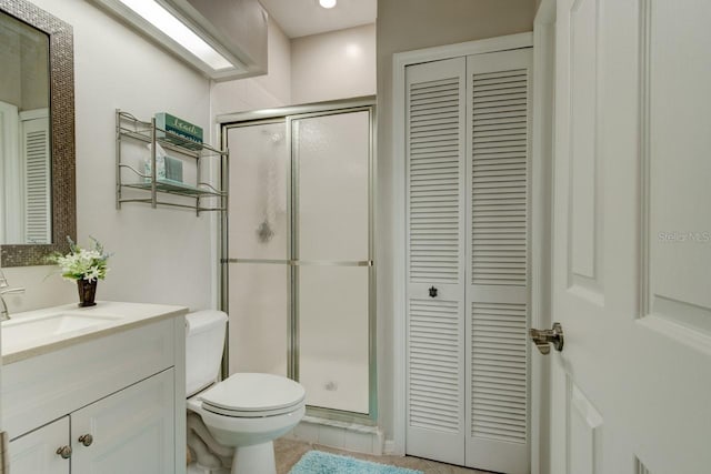 bathroom featuring tile patterned floors, toilet, vanity, and an enclosed shower