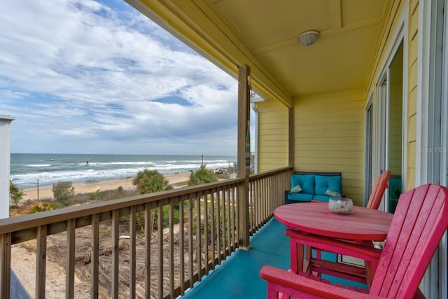 balcony featuring a beach view and a water view