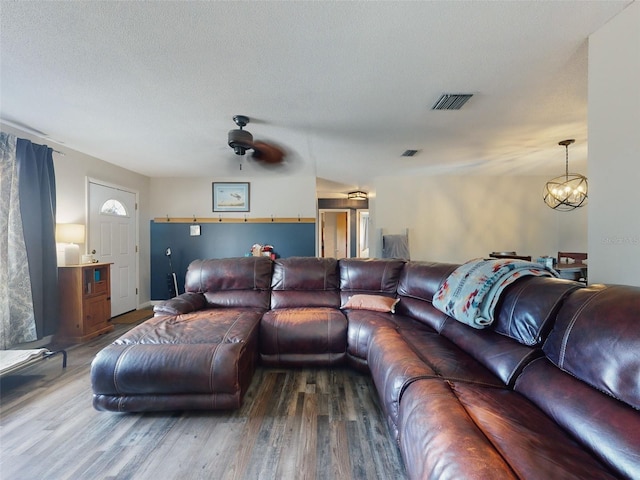 living room featuring a textured ceiling, ceiling fan with notable chandelier, and hardwood / wood-style flooring