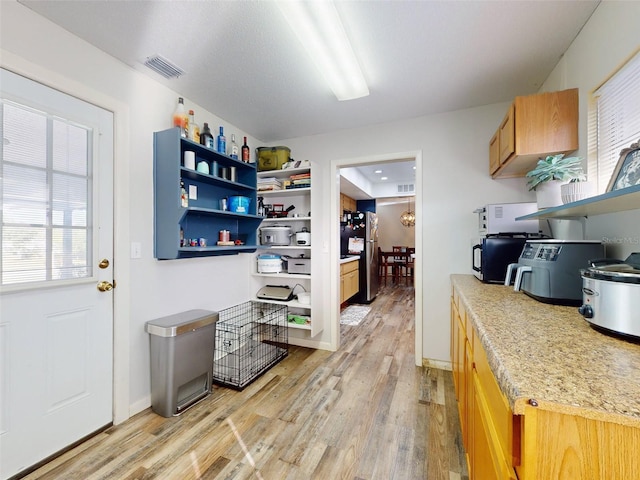 kitchen featuring light hardwood / wood-style floors and stainless steel refrigerator