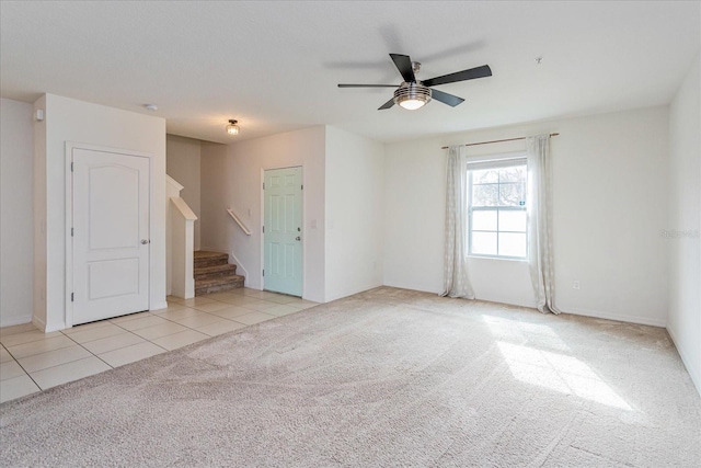 carpeted spare room featuring ceiling fan