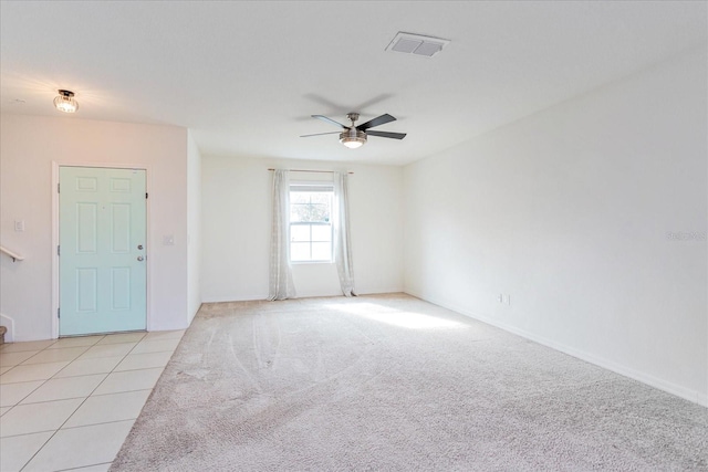 tiled spare room with ceiling fan