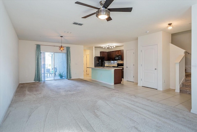 unfurnished living room featuring ceiling fan and light tile patterned flooring