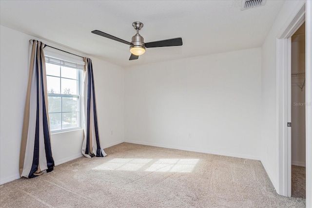 spare room featuring ceiling fan and light carpet