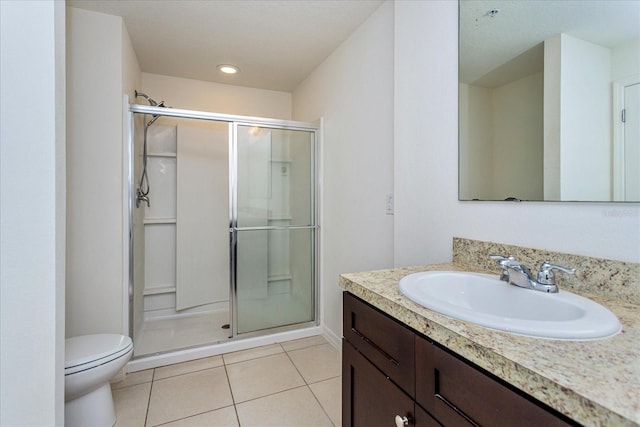 bathroom featuring tile patterned flooring, vanity, toilet, and an enclosed shower