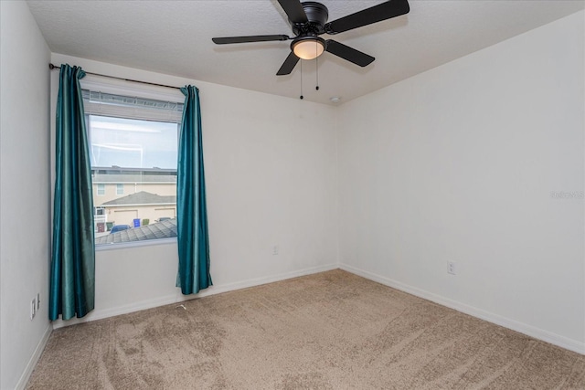 spare room featuring light carpet and ceiling fan