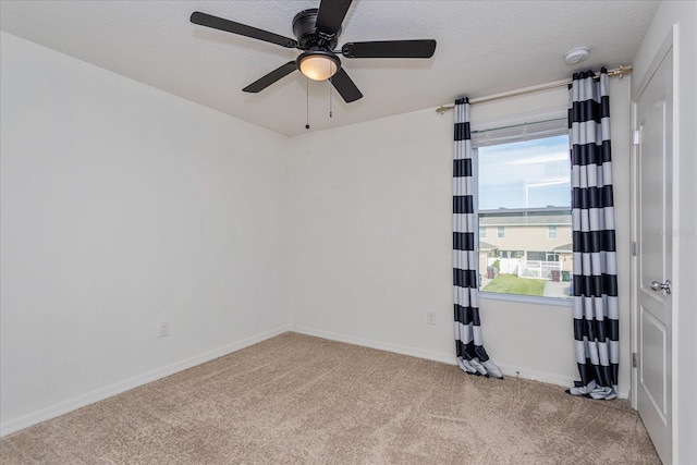 carpeted empty room featuring ceiling fan, plenty of natural light, and a textured ceiling