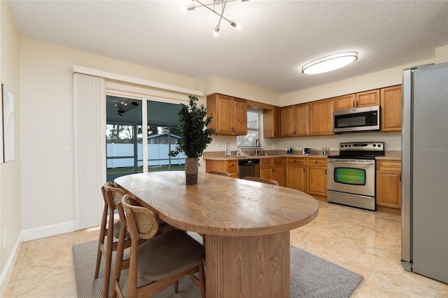 kitchen with sink, a textured ceiling, and appliances with stainless steel finishes