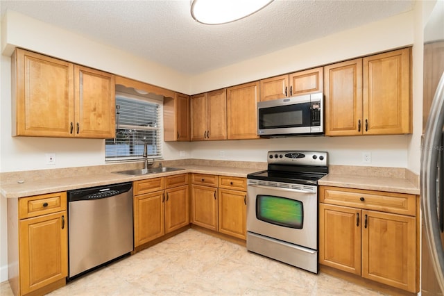 kitchen with sink, stainless steel appliances, and a textured ceiling