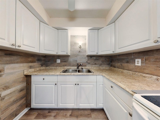 kitchen featuring white cabinets, light stone countertops, electric stove, and sink