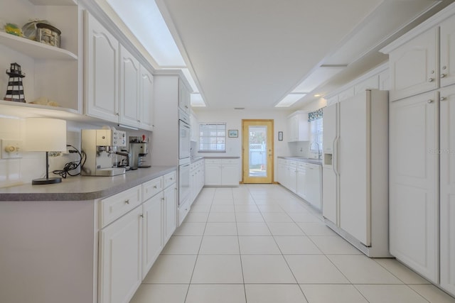 kitchen with backsplash, white cabinets, light tile patterned flooring, and white refrigerator with ice dispenser