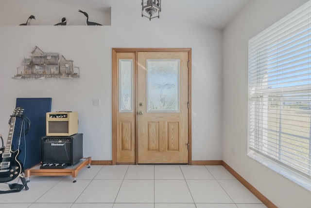 foyer entrance with light tile patterned floors and lofted ceiling