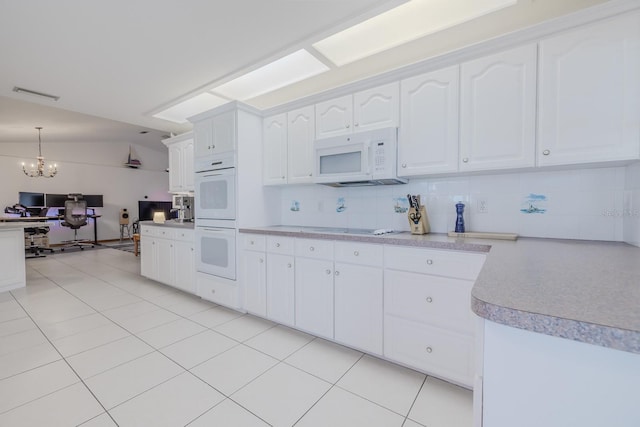 kitchen featuring white appliances, an inviting chandelier, white cabinets, hanging light fixtures, and light tile patterned flooring