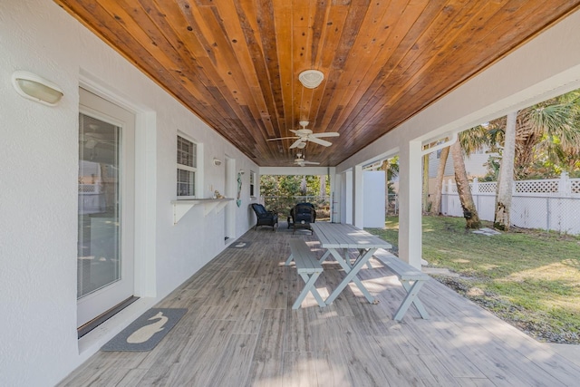 wooden deck with a lawn and ceiling fan