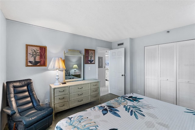 bedroom featuring a closet, a textured ceiling, and dark colored carpet