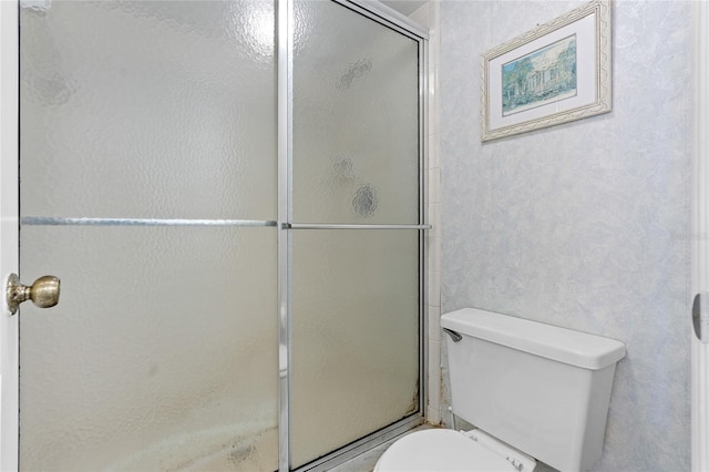 bathroom with toilet and a shower with shower door