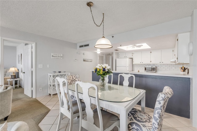 tiled dining space with a textured ceiling