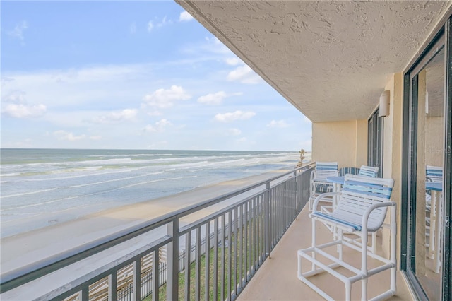 balcony with a water view and a beach view