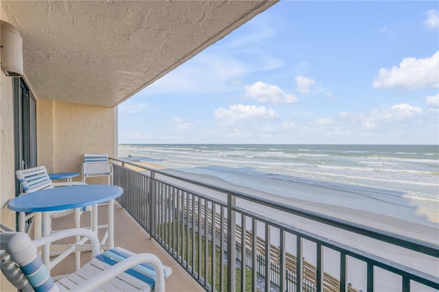 balcony featuring a water view and a beach view