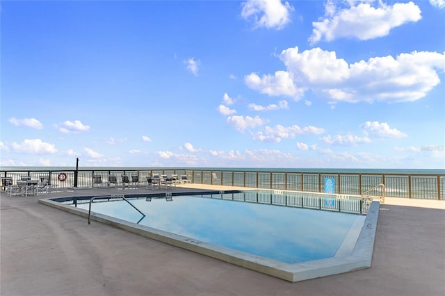 view of swimming pool featuring a water view